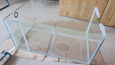 Zusammengeklebte Impfkiste aus dem alten Aquarium und einer kleinen PVC-Platte, damit in diese die Handschuhe befestigt werden. In die PVC-Platte wurden zwei Löcher hinein gesägt!